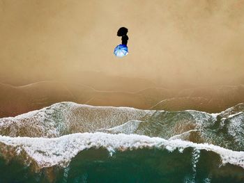 Aerial view of person with umbrella at beach