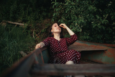 Young woman looking up while sitting outdoors