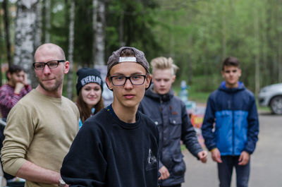 Portrait of friends standing against trees