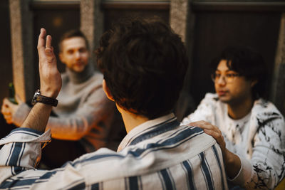 Rear view of people looking at camera