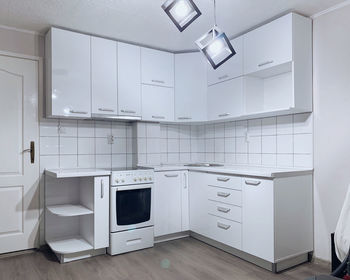 A modern, white, new kitchen with dark floor in a home