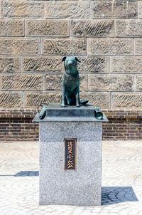 Statue against brick wall