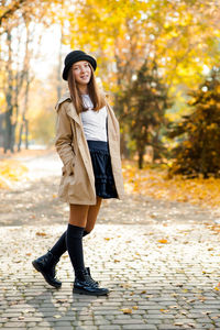 Full length of smiling young woman during autumn