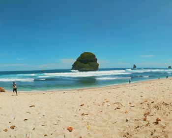 Scenic view of beach against blue sky