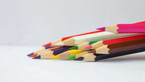 Close-up of multi colored pencils against white background