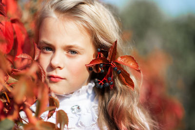 Close-up portrait cute girl by plants in park during autumn