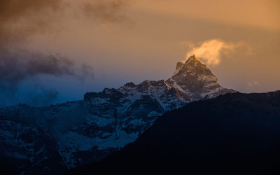 Scenic view of snowcapped mountains against sky during sunset