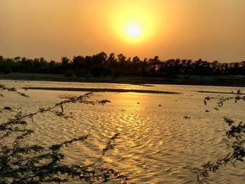 Scenic view of lake against orange sky