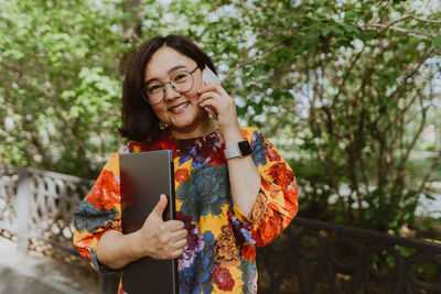 Business lady professional talking on mobile while enjoying nature.