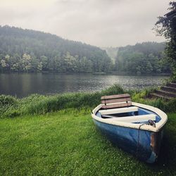 Boat moored on shore by lake