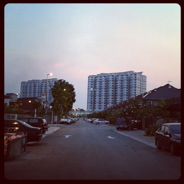 building exterior, architecture, built structure, city, transfer print, the way forward, auto post production filter, sky, street, building, diminishing perspective, road, car, transportation, residential building, skyscraper, residential structure, tower, tall - high, street light