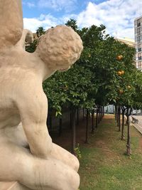 Statue amidst trees against sky