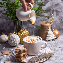 Midsection of person holding coffee cup on table