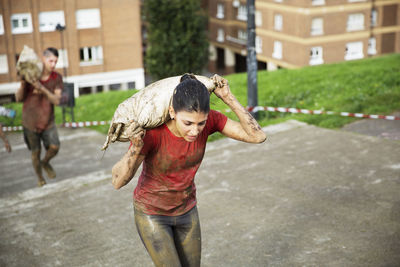 High angle view of participants carrying sandbag and climbing steps during race