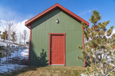 Exterior of house by building against sky during winter