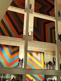 Low angle view of man standing by multi colored building