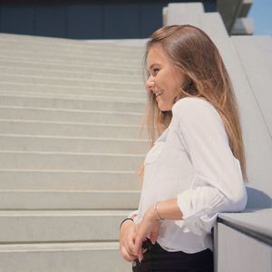 Side view of woman standing on staircase