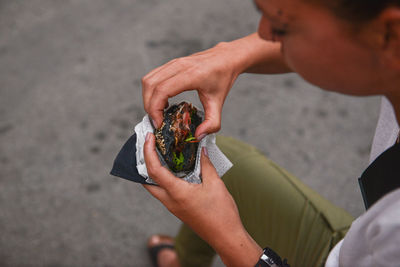 Person holding food on street