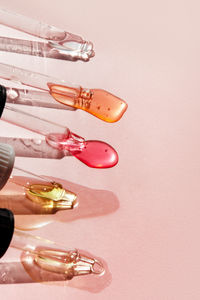 Pipettes with serum and peeling on pink background. cosmetics concept. dose of acid, retinol
