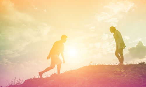 Low angle view of men walking on field against sky