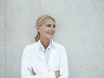 Thoughtful biologist in front of wall