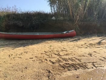 Boat moored on beach against sky