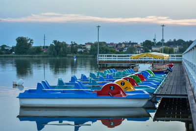 Boats moored in lake against sky