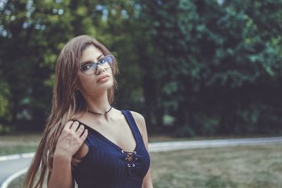 Portrait of young woman wearing eyeglasses while standing at park