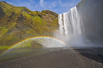 Full rainbow in the mist of colorful skogafoss waterfall in iceland