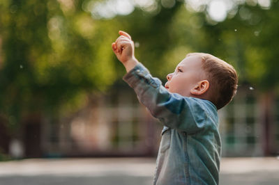 Side view of boy standing outdoors