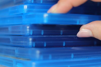 Close-up of hand removing container from stack