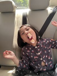 High angle view of cute girl sitting in car