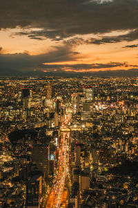 High angle view of illuminated cityscape against sky at sunset