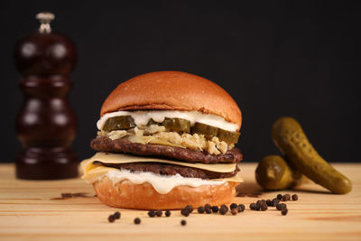 Close-up of burger on table against black background