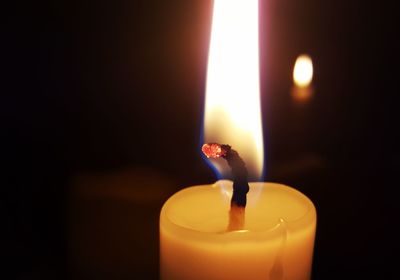 Lit candle in dark room