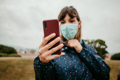 Woman taking selfie against sky