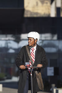 Young businessman in a suit riding an electric scooter at a business meeting. eco transport concept
