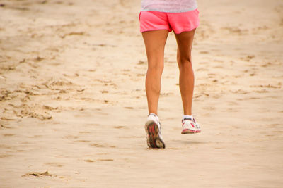 Low section of woman jogging on beach