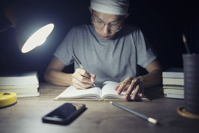 Midsection of man reading book