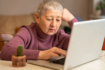 Senior woman using laptop at home