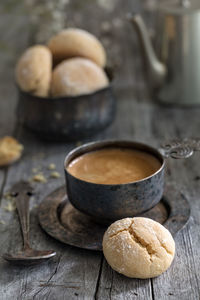 Cup of coffee, pot and cookie on wooden rustic background as a still life vertical composition