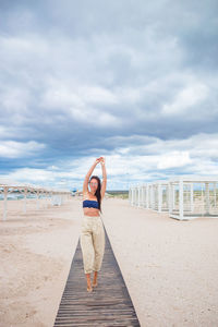 Woman standing on beach against sky