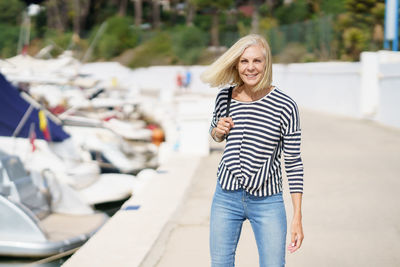 Portrait of smiling young woman walking on street