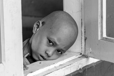 Upset boy looking through window