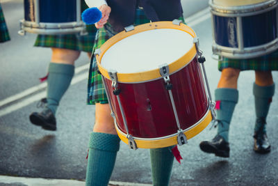 Musicians wearing uniform playing drums on street in city