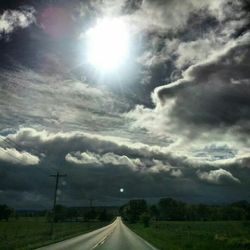 Country road against cloudy sky