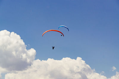 Low angle view of person paragliding against sky