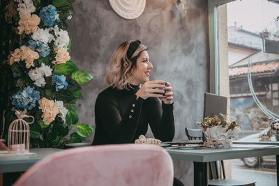 Woman sitting on table in restaurant