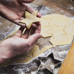 High angle view of hand holding star shape cookies on table