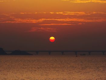 Scenic view of sea against dramatic sky during sunset